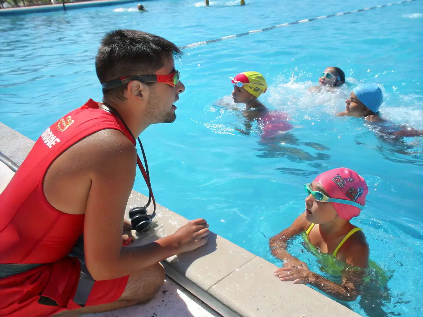 A lifeguard supervising a swimming class, ensuring safety and providing guidance to participants of various ages.
